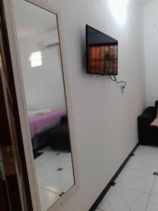 espejo en una habitación con TV y sofá en Residência dos Félix, en Morro de São Paulo