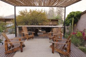 a patio with two wooden chairs and a table at UMA Hotel in Pisco Elqui
