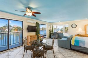 um quarto com uma cama e uma sala de estar com uma televisão em Bayview Plaza Waterfront Resort em St. Pete Beach