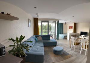 - un salon avec un canapé bleu et une table dans l'établissement Saulės spindulio apartamentai, à Palanga