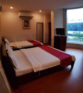 a bedroom with two beds and a large window at Linh Phương 1 Hotel in Can Tho