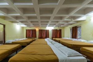 a row of beds in a room with curtains at KSTDC Hotel Mayura Hoysala, Mysore in Mysore +50 photos