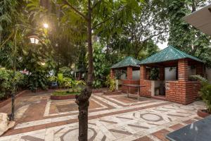 un pequeño edificio con un árbol en un patio en KSTDC Hotel Mayura Hoysala, Mysore en Mysore