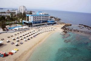 una vista aérea de una playa con sombrillas y el océano en Arkin Palm Beach Hotel en Famagusta