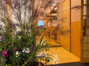 un couloir avec des plantes et des fleurs dans un bâtiment dans l'établissement Hotel & Onsen 2307 Shigakogen, à Yamanouchi