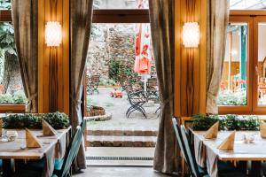 una sala da pranzo con tavoli, sedie e una finestra di Gasthof Mang a Ybbs an der Donau