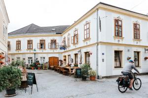 
a person sitting on a bench in front of a building at Gasthof Mang in Ybbs an der Donau
