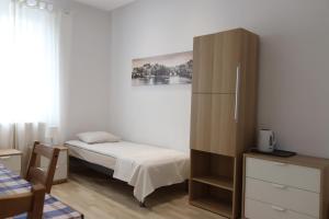niewielka sypialnia z łóżkiem i szafką w obiekcie City Apartments & Gym we Wrocławiu