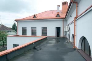 una pasarela que conduce a un edificio blanco con techo rojo en Laurentroom Center en Ukmergė