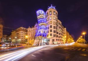 a city street at night with tall buildings at Dancing House - Tančící dům hotel in Prague