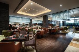 a restaurant with tables and chairs in a room at Hotel Nikko Suzhou in Suzhou