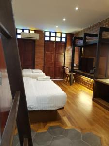 a bedroom with two bunk beds and a flat screen tv at Little Kampung Studio in Teluk Intan