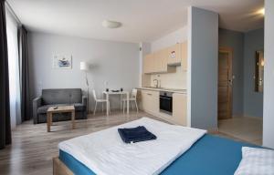 a bedroom with a bed and a kitchen with a couch at Parkowa 13 in Szczecin