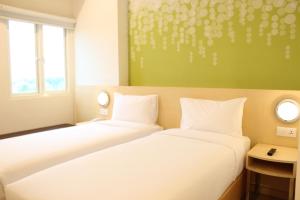 Postel nebo postele na pokoji v ubytování Zest Parang Raja Solo by Swiss-Belhotel International