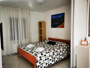 um quarto com uma cama com um cobertor xadrez preto e branco em Krasen Kras Apartment em Komen