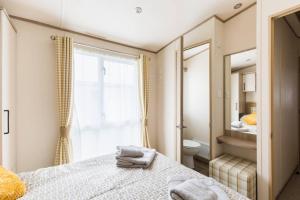 a bedroom with a bed and a window and a toilet at Duckling View in South Cerney +43 photos