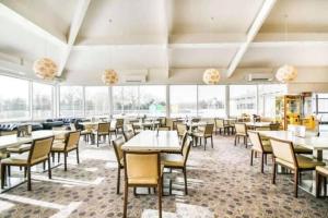 a dining room with tables and chairs and windows at Duckling View in South Cerney