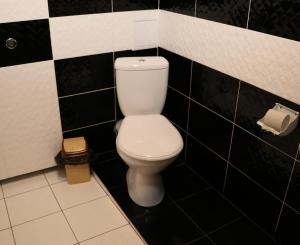 ザポリージャにあるSmart Hotel on Gogolyaの黒いタイル張りのバスルーム(白いトイレ付)