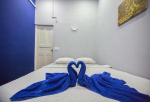 two blue towels are forming a heart on a bed at The Artist Residence in Phnom Penh