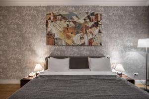 1 dormitorio con 1 cama y una pintura en la pared en Cityhotel Apartments, en Kiev
