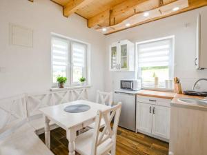 a white kitchen with a table and a table and a table and a tablektop at Czadzia Przystań in Czarna