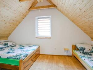 two beds in a small room with a window at Czadzia Przystań in Czarna