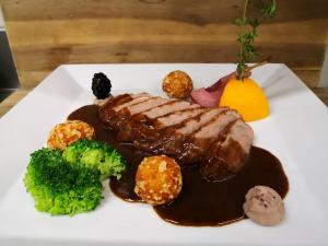 un plato blanco de comida con carne y verduras en Landhotel Drei Eichen en Eugendorf