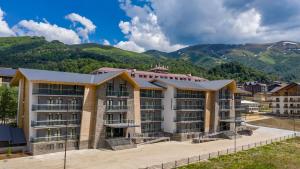 un condominio con montagne sullo sfondo di Crystal Resort a Bakuriani