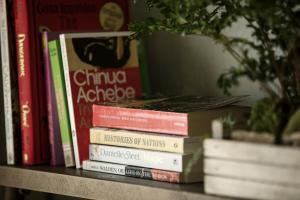 a pile of books sitting on a shelf at Valsana Hotel Arosa - Small Luxury Hotels of the World in Arosa