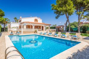 a swimming pool in front of a house at Villa Menorca Jalima 1 by Mauter Villas in Cala Blanca