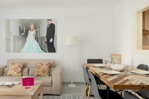 a living room filled with furniture and a painting at Caleta Homes - Apartamentos Pompidou in Málaga