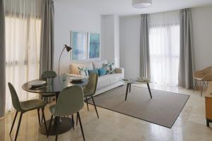 a living room with a table and a couch at Caleta Homes - Ancha del Carmen in Málaga