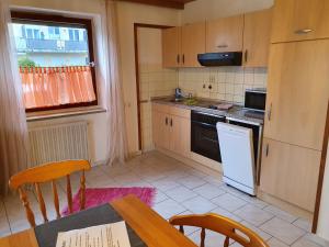 eine Küche mit einem Tisch und einem weißen Kühlschrank in der Unterkunft Ferienwohnung Sirch in Diedorf