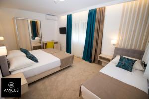 Habitación de hotel con 2 camas y espejo en Hotel Amicus, en Mostar