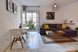 een woonkamer met een bank en een tafel bij Apartamentos Tribuna in Málaga