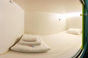 a small room with a bed and a mirror at Хостел 689CapsuleHotel&Coffee in Almaty