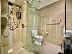 a bathroom with a glass shower with a toilet at Homesuite' Home at Aeropod SOVO in Kota Kinabalu