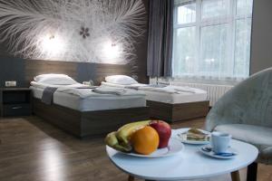 a room with two beds and a table with fruit on it at Hotel Ezeroto in Stara Zagora