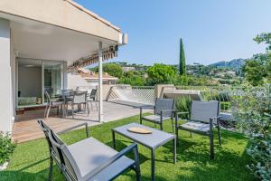 un patio con sillas y mesas en el césped en Le Canaio Upper Club par Dodo-a-Cassis, en Cassis