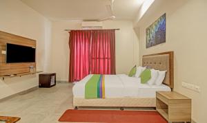 a bedroom with a large bed and a television at Itsy By Treebo - Tao Residency 2 Minutes Walk From Baga Beach in Old Goa