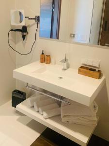 ein Badezimmer mit einem Waschbecken, einem Spiegel und Handtüchern in der Unterkunft Buchberg38 in Buchberg bei Herberstein