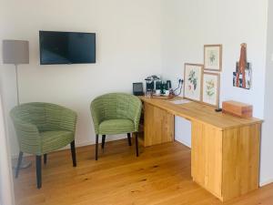 Zimmer mit einem Schreibtisch und 2 grünen Stühlen in der Unterkunft Buchberg38 in Buchberg bei Herberstein