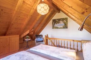 ein Schlafzimmer in einem Blockhaus mit einem Bett und einem Kronleuchter in der Unterkunft Haus Desor in Kressbronn am Bodensee