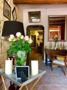 a room with a table with a vase of roses at La Maison dans les remparts in Aigues-Mortes