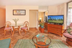 sala de estar con mesa y TV en Island Sands Resort 305 en Maalaea