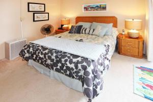 1 dormitorio con 1 cama grande con manta blanca y negra en Island Sands Resort 305 en Maalaea