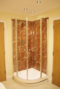 y baño de mármol marrón con ducha de cristal. en Pirn Mill Self Catering Cottage, en Cladich 23 fotos más