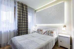 ザコパネにあるApartament Kornelówka - Rezydencja do Skoczni Zakopaneのベッドルーム1室(白いベッド1台、枕付)、窓が備わります。
