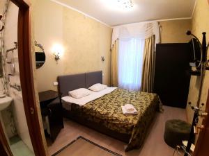 a hotel room with a bed and a bathroom at Гостевой Дом ЛИМОН in Saint Petersburg