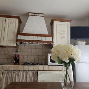 a vase of white flowers on a table in a kitchen at VINTAGE HOME in Sassari